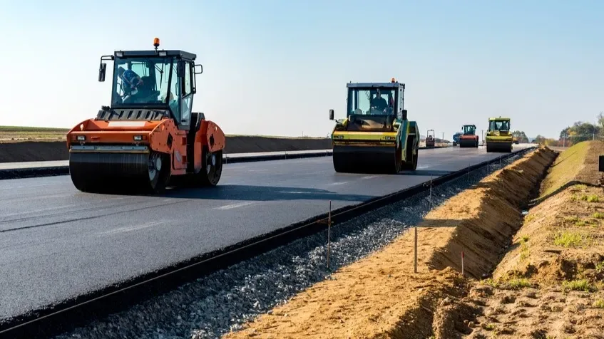 Road construction equipment working on a paved corridor